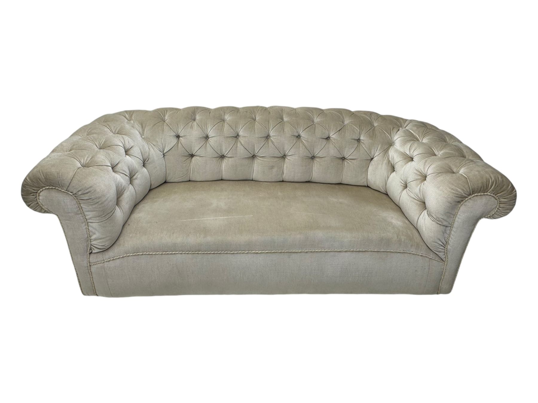 Chesterfield shaped button-tufted sofa, upholstered in pale beige velvet fabric with rolled arms, decorative rope trim and ruched detailing