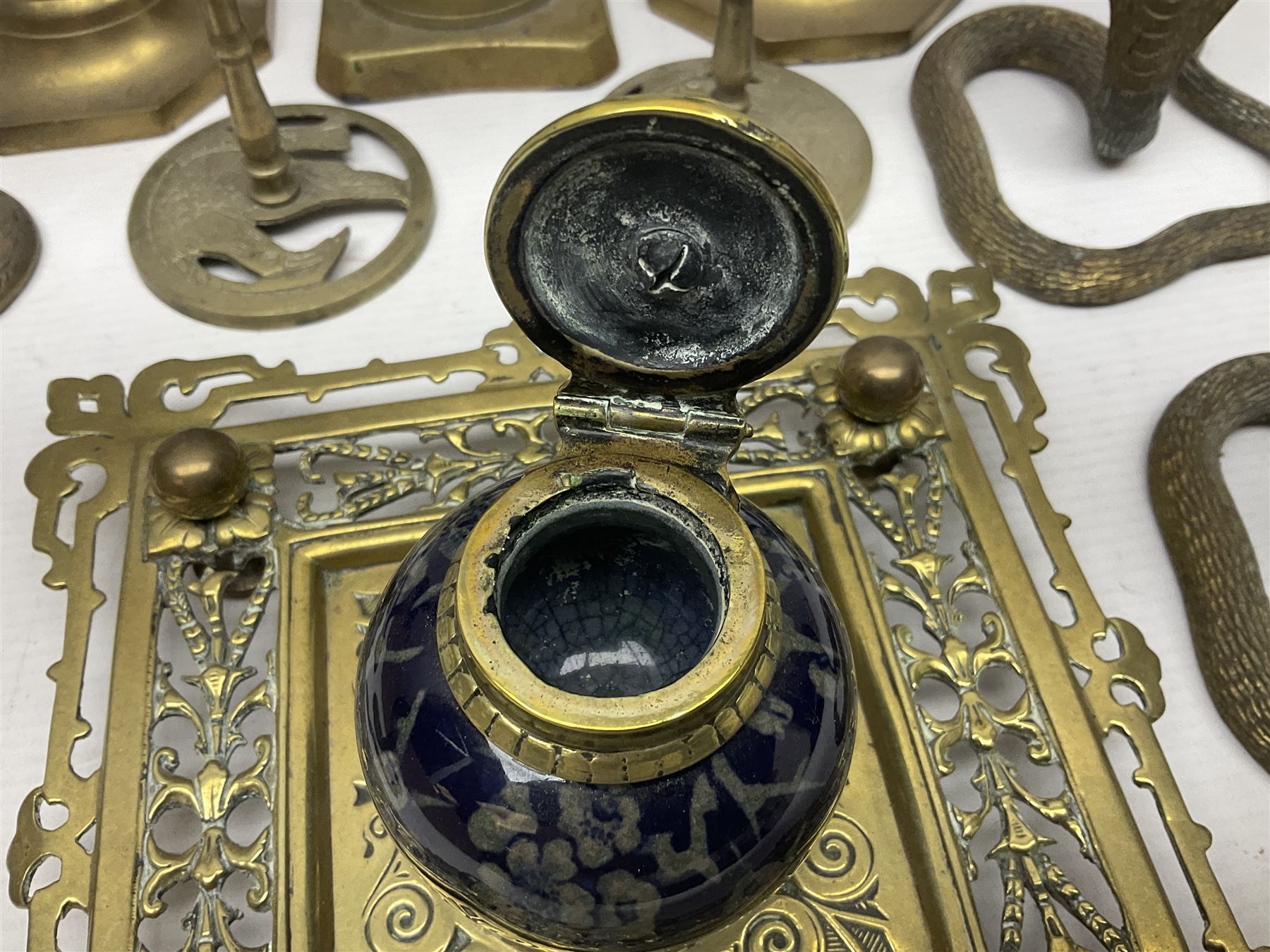 Brass inkstand, of square form, pierced, inset with blue and white ceramic inkwell to centre, together with a collation of brass candlesticks 