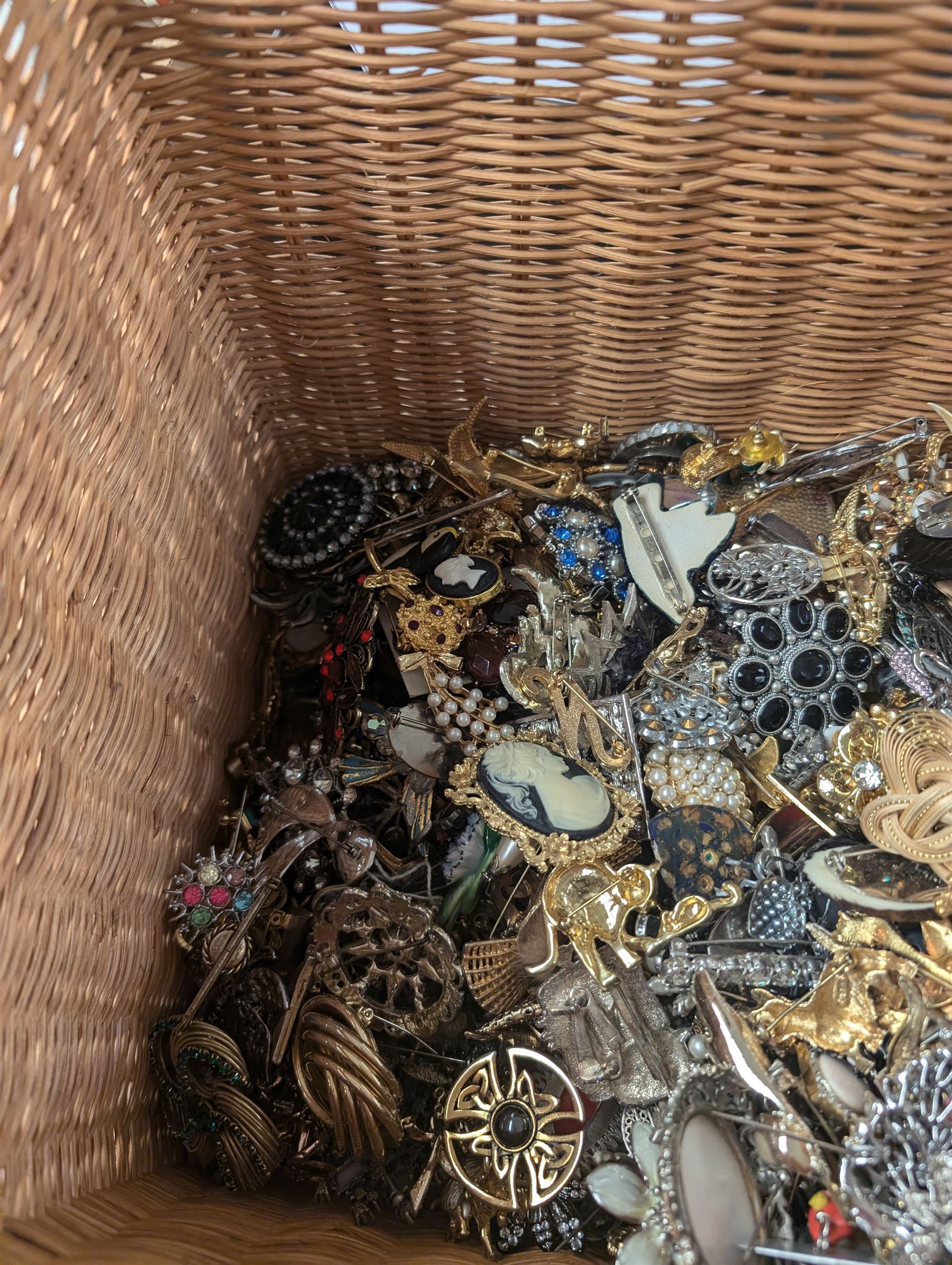 Collection of costume brooches, including ceramic, novelty and animal examples, contained within an wicker basket box