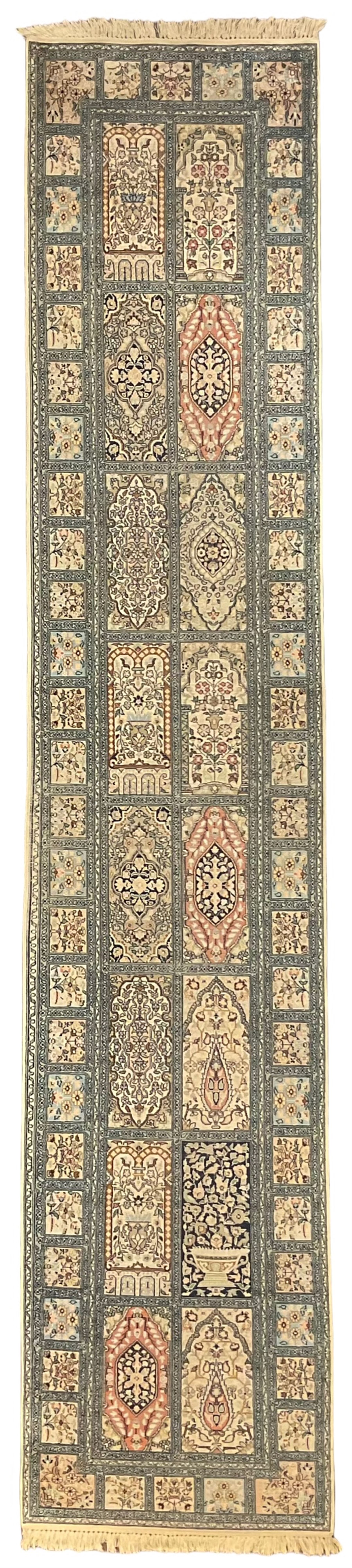 Fine Persian Kashmir ivory and pale indigo ground runner rug, the field decorated with sixteen rectangular panels depicting Mirab motifs and other traditional carpet designs, the border with repeating square panels of floral bouquets and foliate patterns