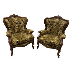 Pair of Victorian design stained beech armchairs, upholstered in leopard print fabric, with carved top rail over button-tufted backrest, scroll arms, serpentine front rail, raised on cariole supports