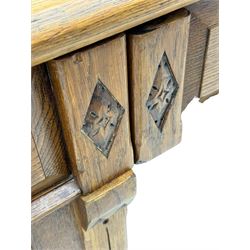 Late Victorian oak twin pedestal desk, chamfered rectangular top over three convex front edge drawers and two panelled cupboards, flanked by carved supports with roundels and diamond motif, on bracketed plinth base