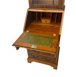 Mid-to-late 20th century yew wood bureau bookcase, raised bookcase enclosed by glazed door, the fall front revealing fitted interior, four graduating cock-beaded drawers below, on bracket feet