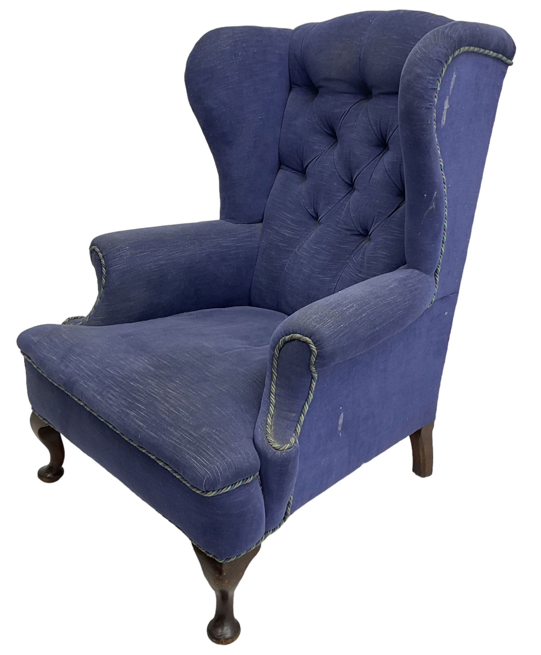 Early 20th century wingback armchair, upholstered in buttoned blue fabric, rolled and scrolled arms, on cabriole feet