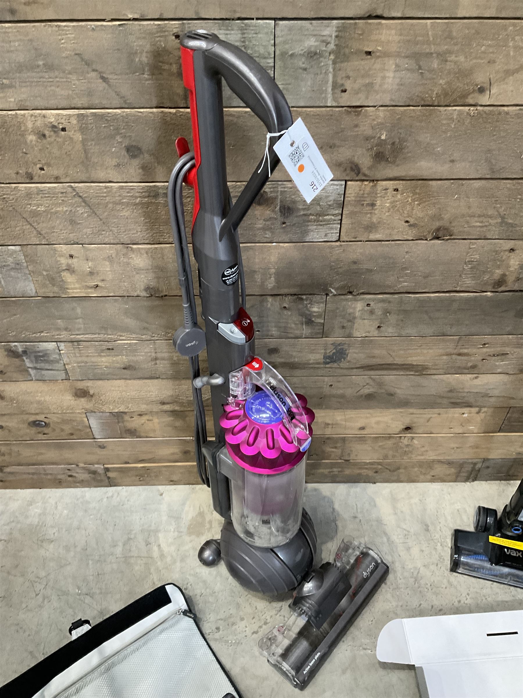 Dyson DC40 vacuum cleaner with various attachments, and a Vax cordless vacuum cleaner with single battery and charger