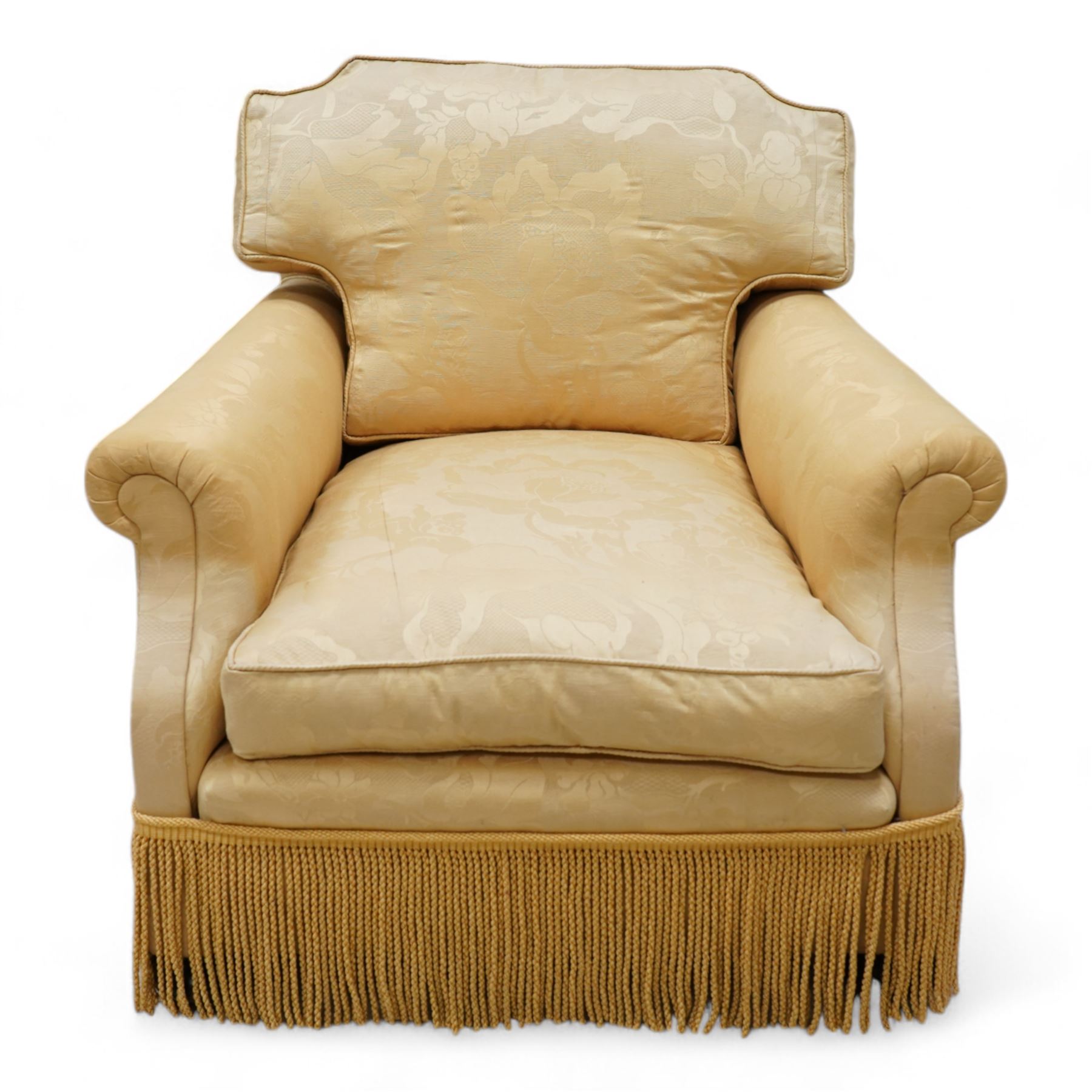 Early 20th century hardwood-framed armchair, shaped cresting over rolled arms, upholstered in floral pattern gold silk fabric with fringe, on turned front feet with recessed castors 