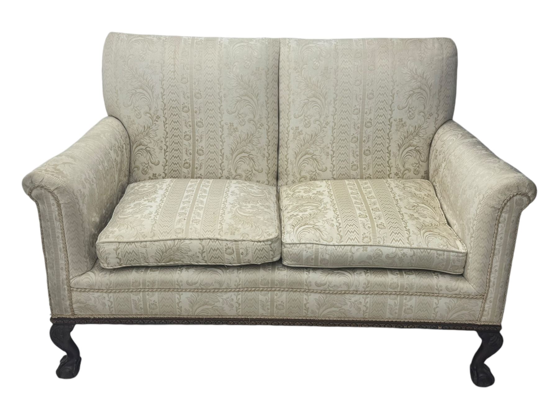 Early 20th century mahogany framed two-seat sofa, upholstered in pale fabric decorated with scrolling foliage, on acanthus carved ball and claw cabriole feet 