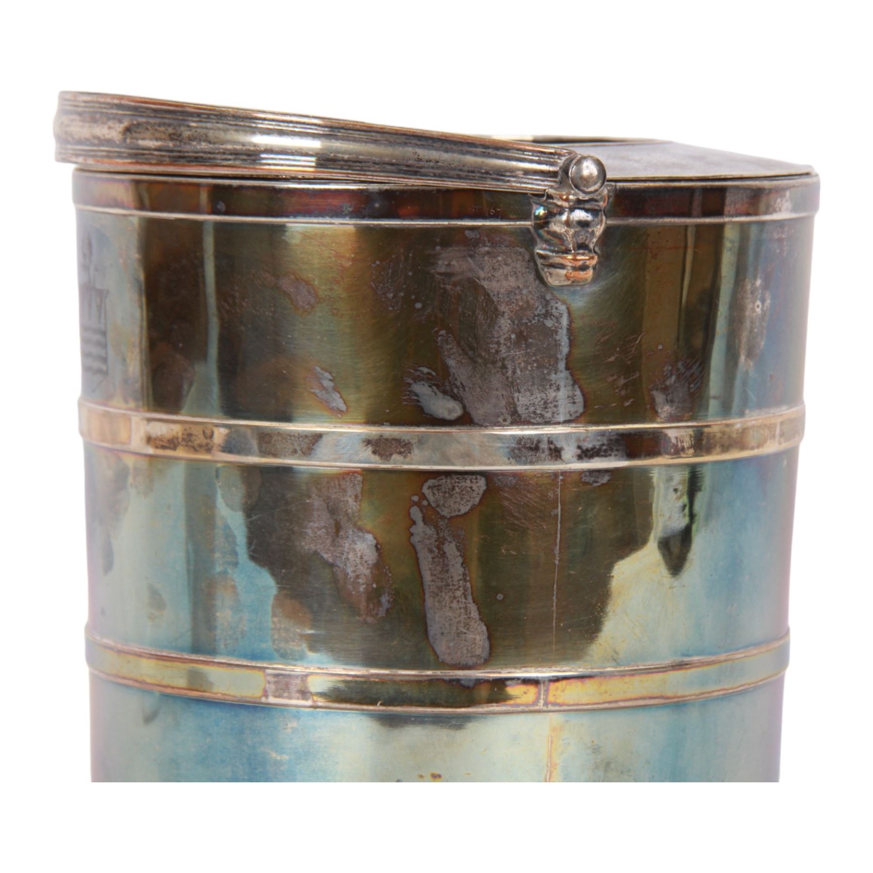 20th century silver plated wine cooler, of cylindrical form with swing handle, two applied bands to body, and engraved crest, the cover lifting to reveal a further removable pierced section, not including handle H20.5cm D20cm