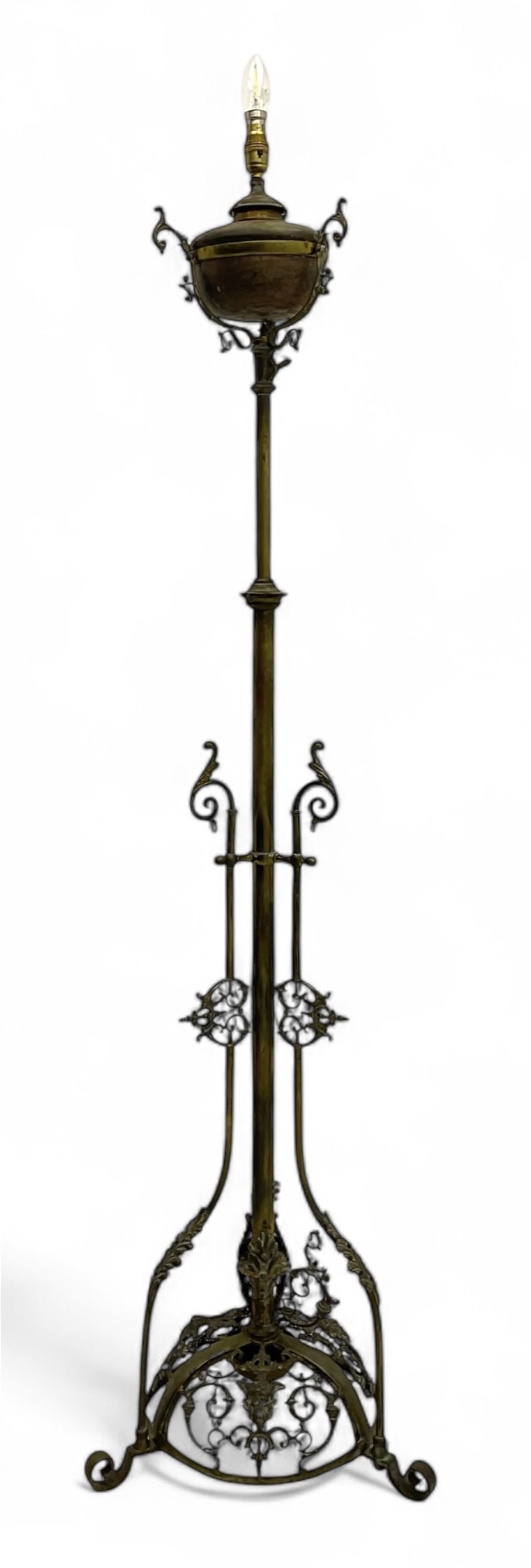 Victorian brass converted oil lamp stand, telescopic stem with scrolled uprights terminating to scrolled feet, dished base decorated with scrolling cast metal work and grotesque masks 