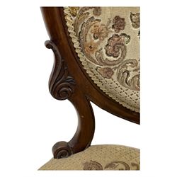 Pair of Victorian walnut lady's and gentleman's drawing room chairs, arched cresting rail carved with cartouche and extending foliage, upholstered in floral pattern fabric, on foliate carved cabriole feet