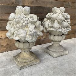 Pair of cast stone garden wall or gate finials depicting Fruit Piers, raised on separate circular squat column with plinth base