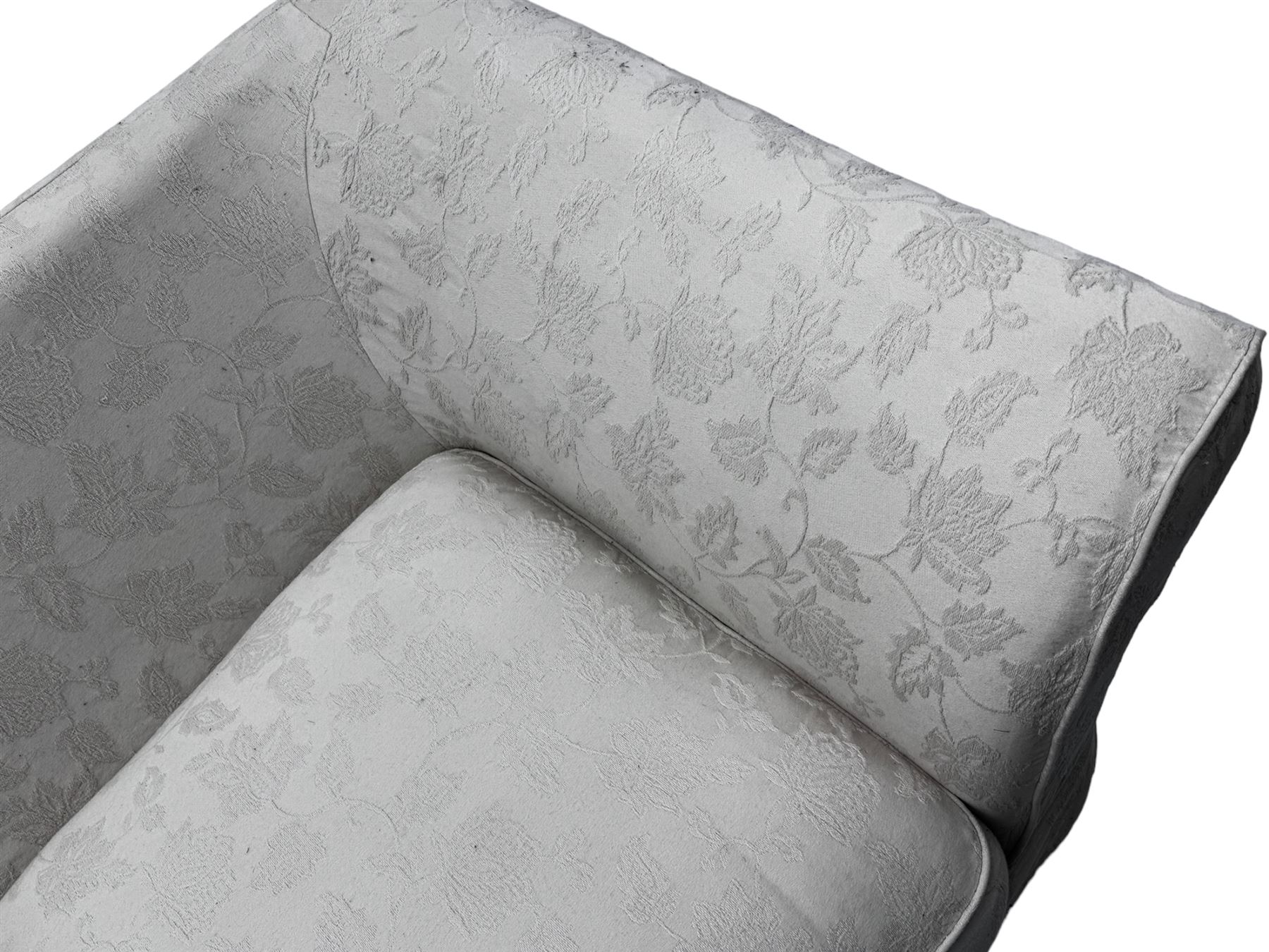 Two-seat traditionally shaped sofa, upholstered in pale floral pattern fabric, with additional covers