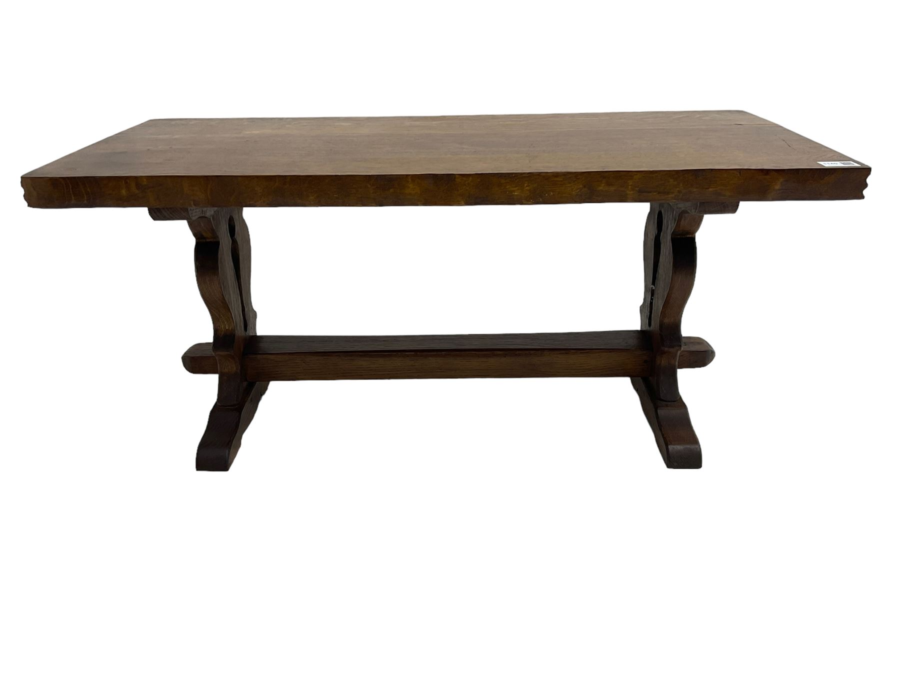 Solid oak coffee table, rectangular waved cut top with tooled ends, on shaped and pierced end supports joined by pegged stretcher 