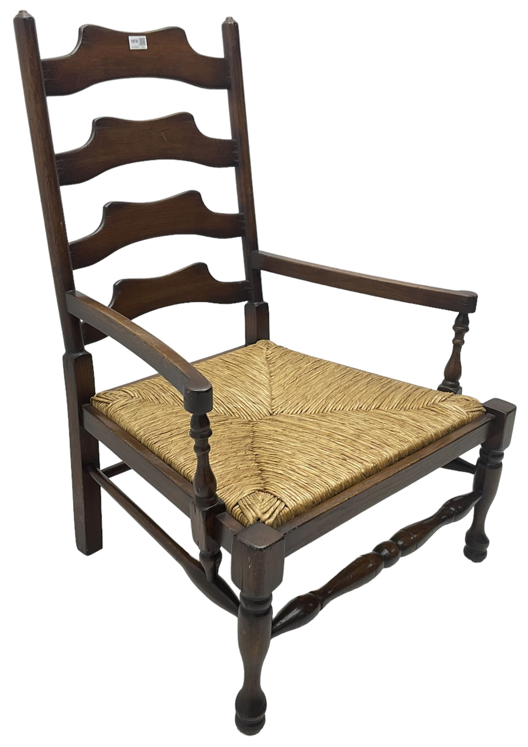 Georgian design oak country low armchair, waived ladder back over rush seat, raised on turned  supports united by stretchers; together with matching stool