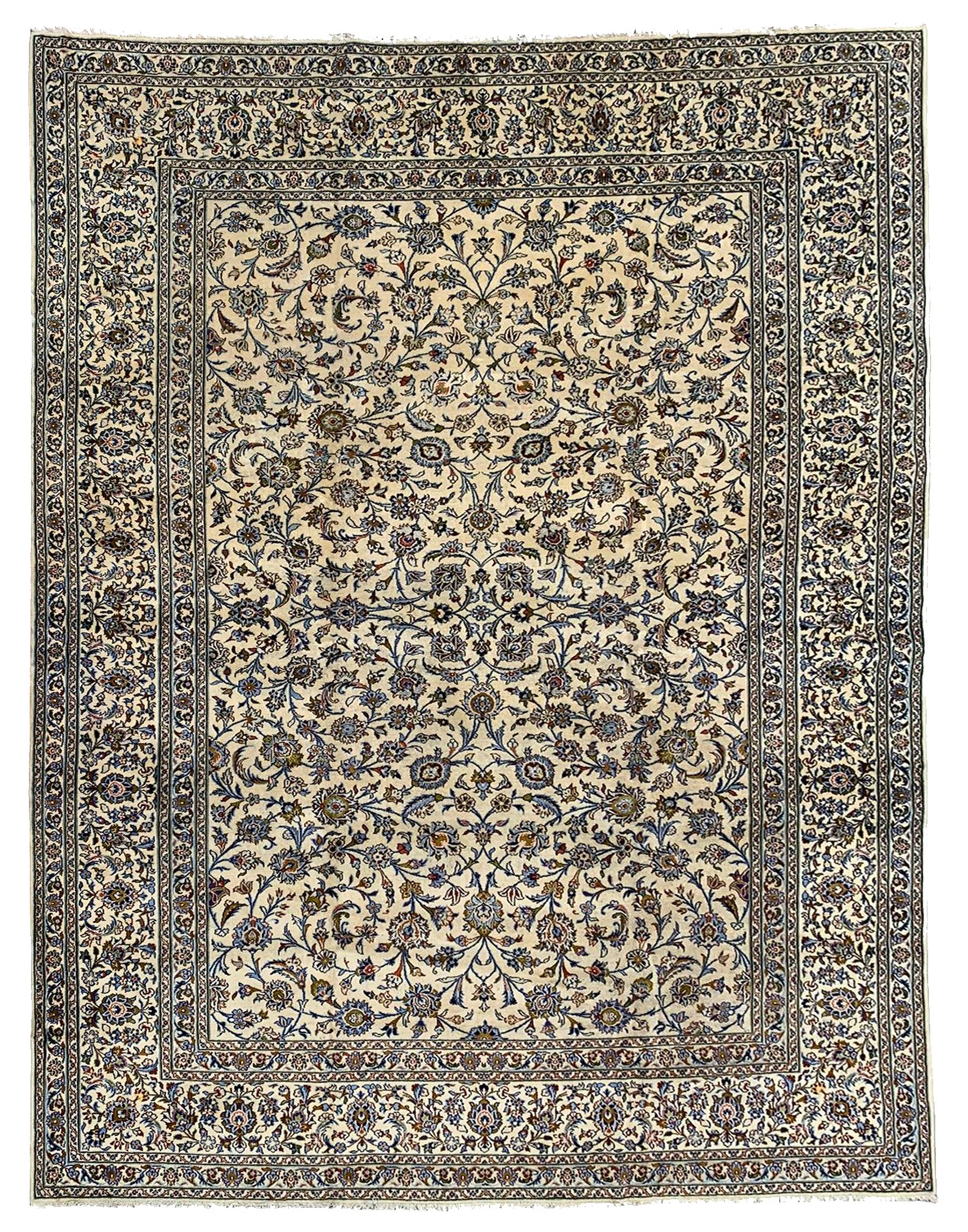 Persian Kashan ivory ground carpet, the field decorated with interlacing leafy branches and stylised plant motifs, repeating border with multiple guards