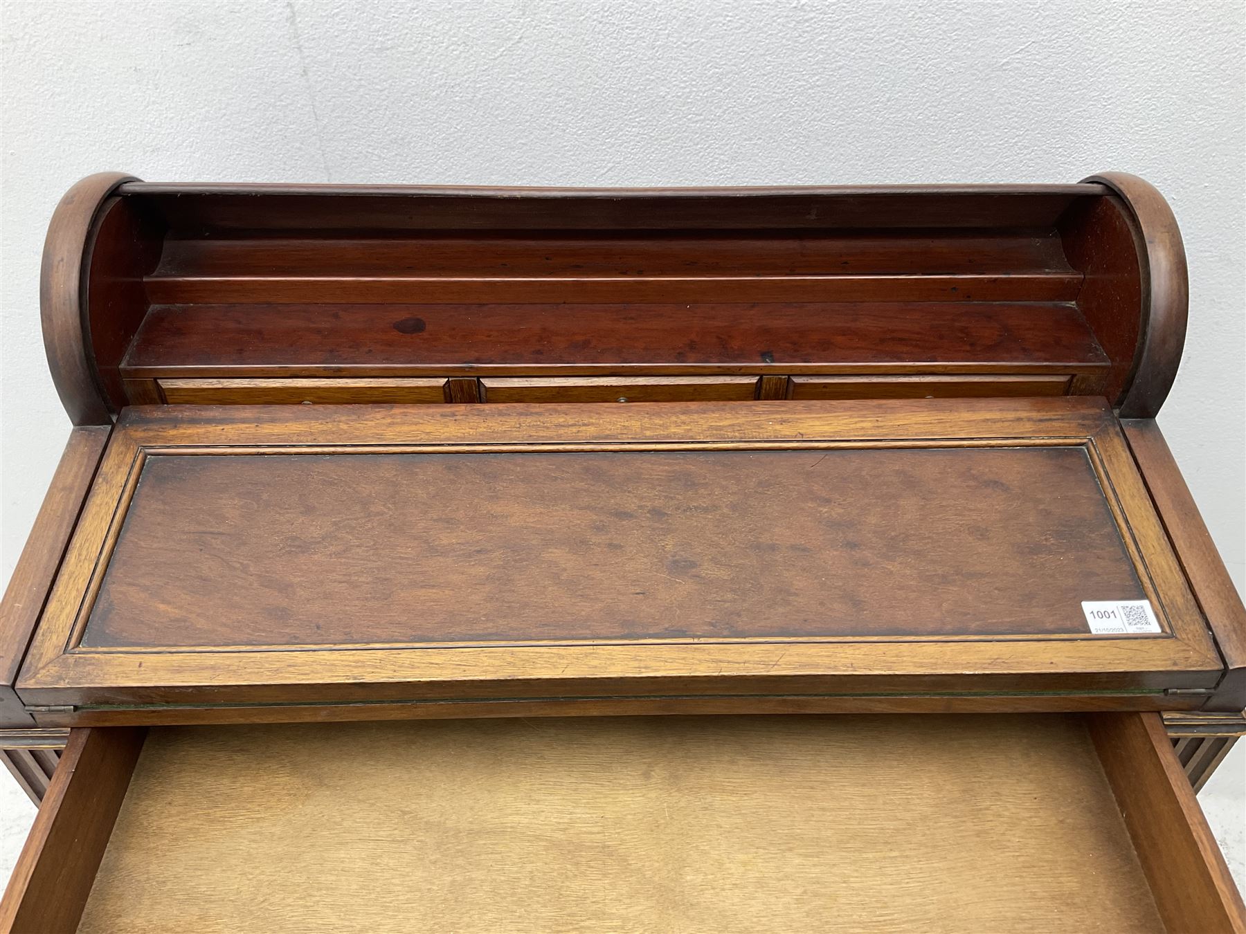 Early 20th century French plum pudding mahogany petite writing desk, barrel tambour roll top, fitted with a single cock-beaded drawer activating the tambour roll, the fold-over writing slope with inset writing surface supported by long drawer, fitted with three small drawers and pen rail, raised on fluted tapering supports