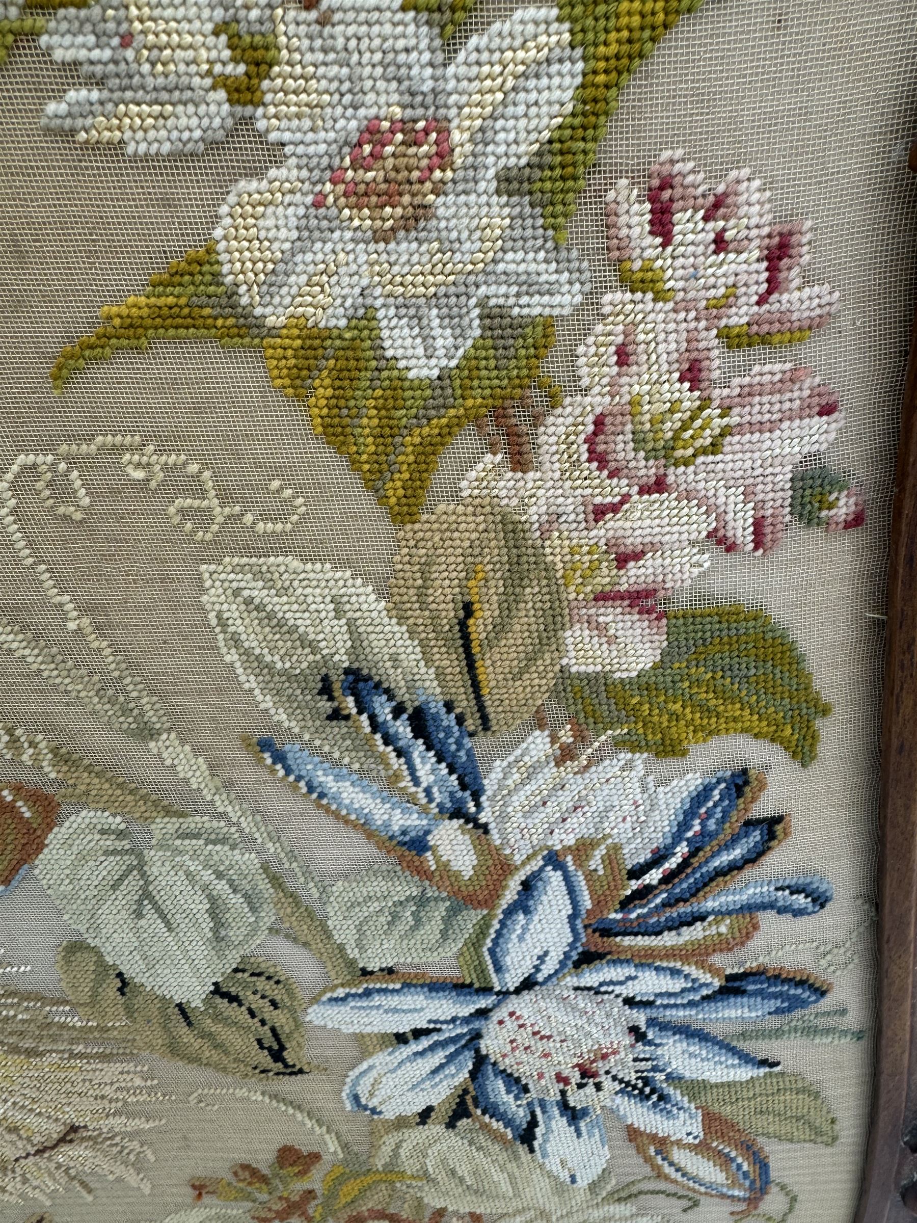 Early 20th century walnut carved needlepoint wall panel, depicting peacock amongst a floral arrangement, framed by carved border with scrolled crest and acanthus leaf accents