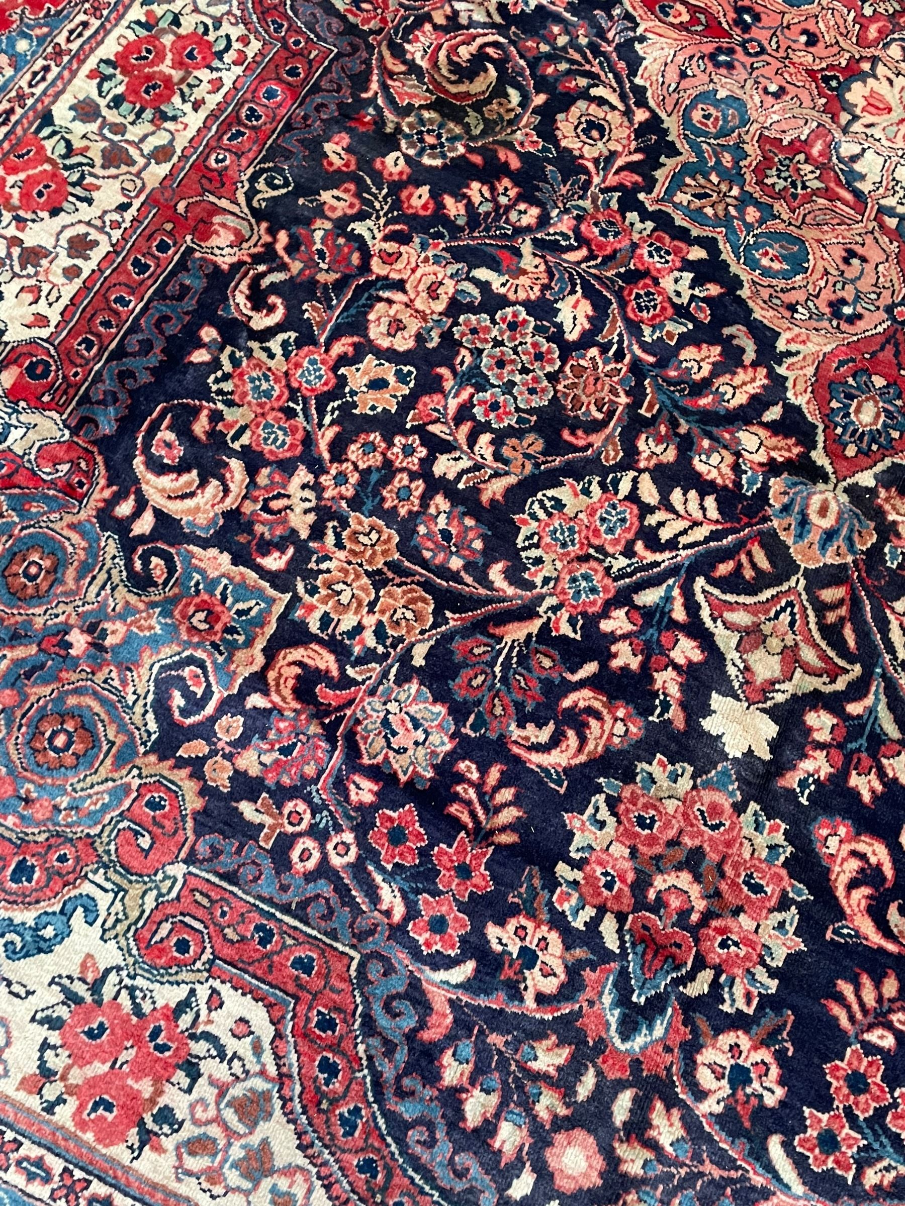 Persian Mahal indigo ground carpet, floral medallion on a field of swirling leafy branches and flower heads, shaped ivory field band decorated with flower head bouquets and trailing branches, the border decorated with floral motifs, within guard stripes