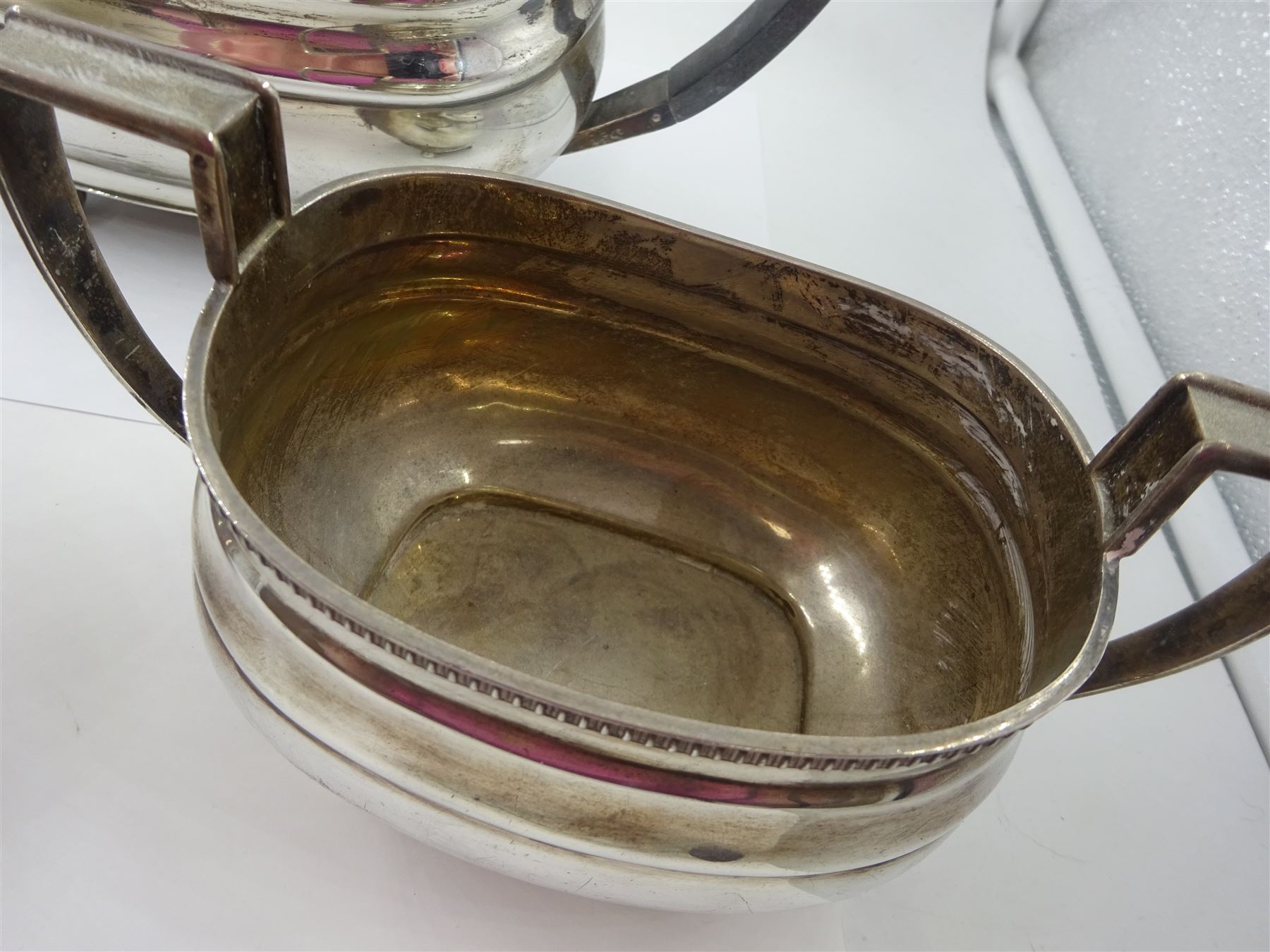 1930s silver three piece tea service, comprising teapot, open sucrier and milk jug, each of oval form with oblique gadrooned rim, the teapot with Bakelite handle and finial, hallmarked James Dixon & Sons Ltd, Sheffield 1932