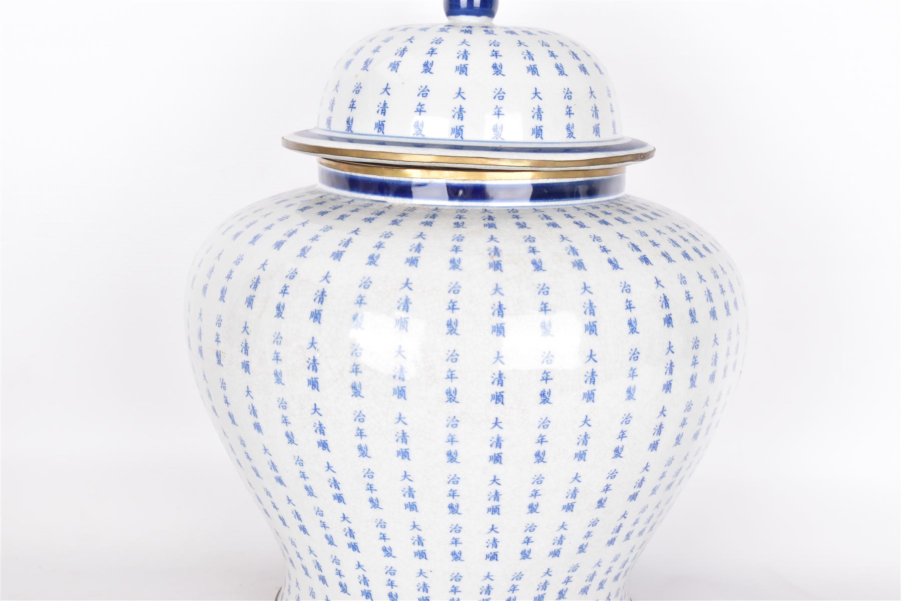 Large Oriental design ginger jar and cover, of squat baluster form with domed cover, decorated in blue with Chinese characters against a white crackle glaze ground, the cover, neck and foot rim with applied brass band, with character mark beneath, H43cm