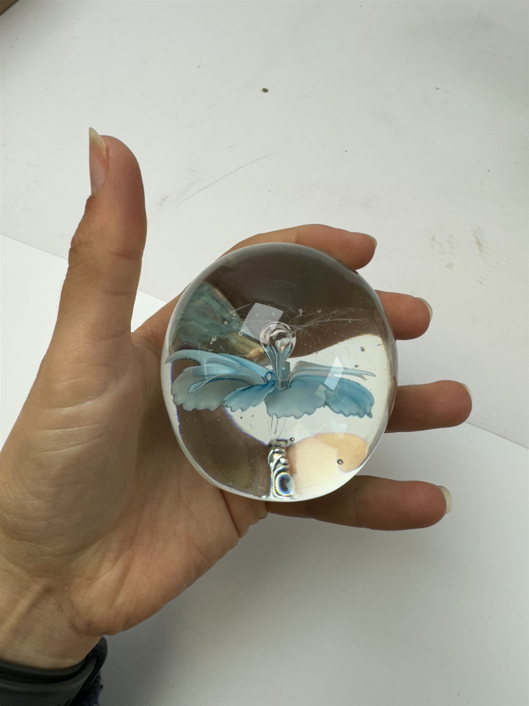 Two glass dump paperweights, with flower inclusions, together with four further glass paperweights