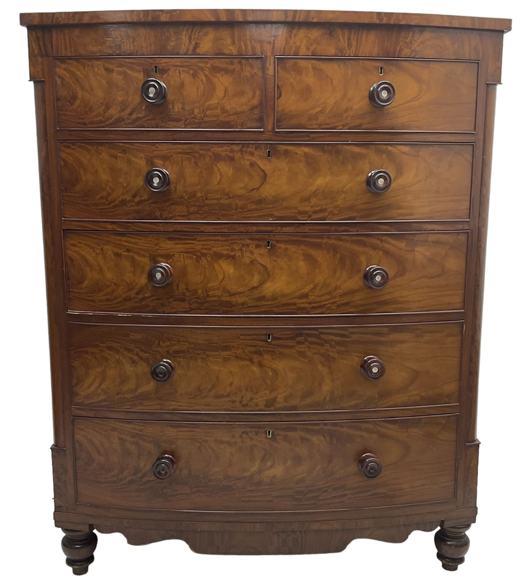 Tall Victorian mahogany bow-front chest, fitted with two short over four long cock-beaded drawers, with turned handles, canted upright corners with quarter columns, shaped apron, on turned feet