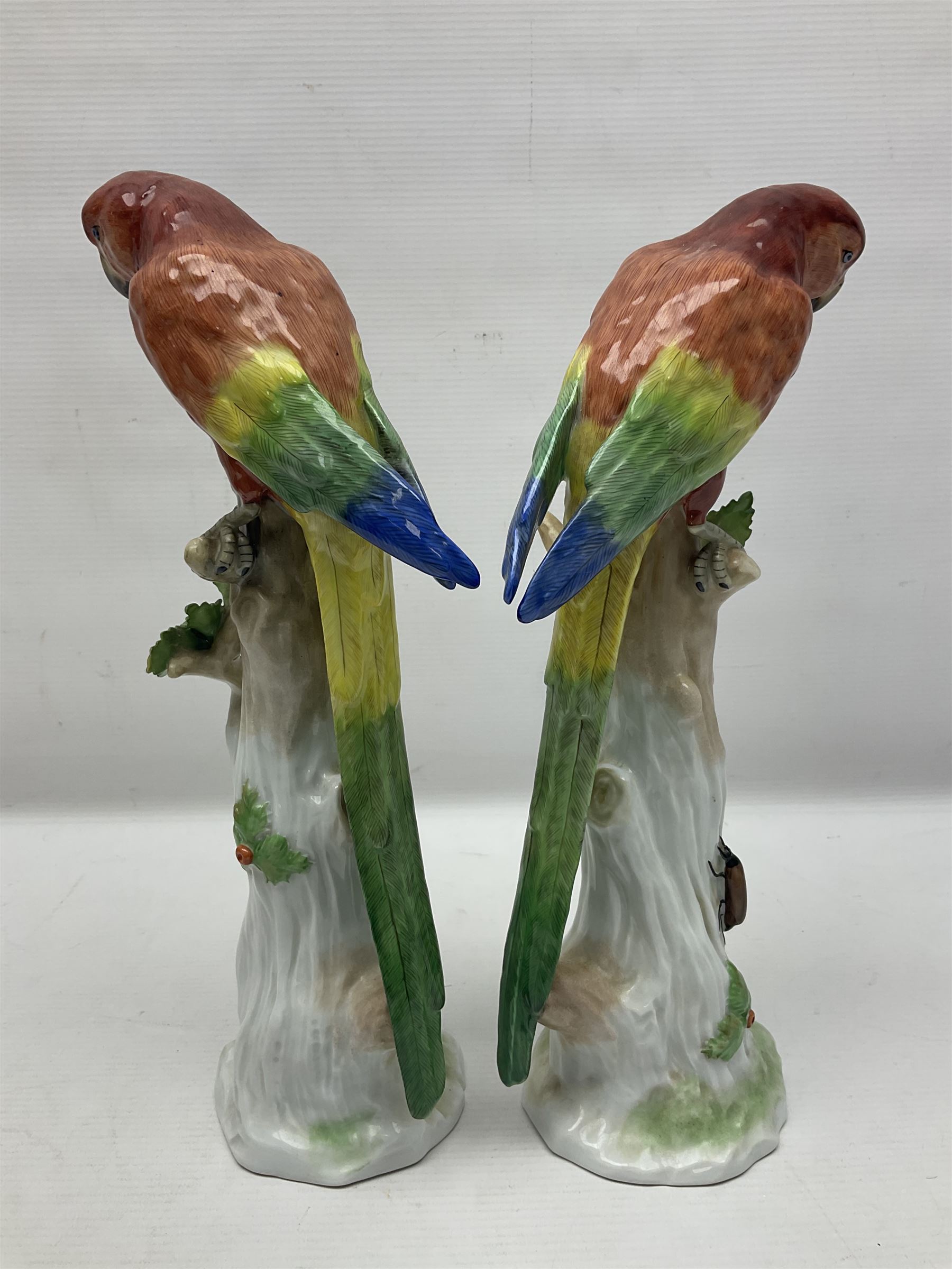 Pair of 20th century Dresden figures, modeled as parrot perched upon a tree stump, with makers mark beneath, H32cm 