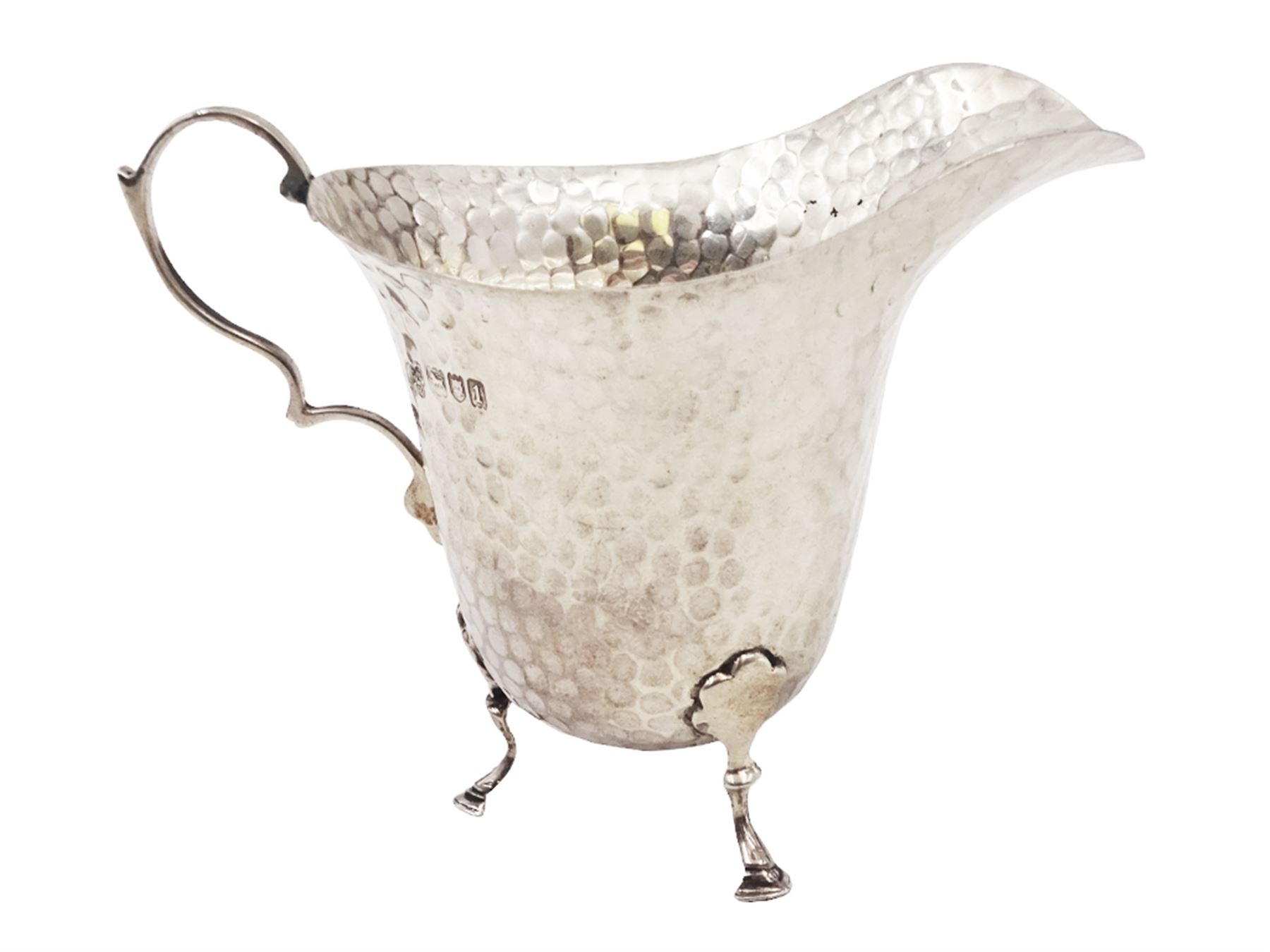 Edwardian silver jug, of helmet form with planished decoration throughout, upon three hoof feet, hallmarked Charles Boyton & Son Ltd, London 1906, H9cm