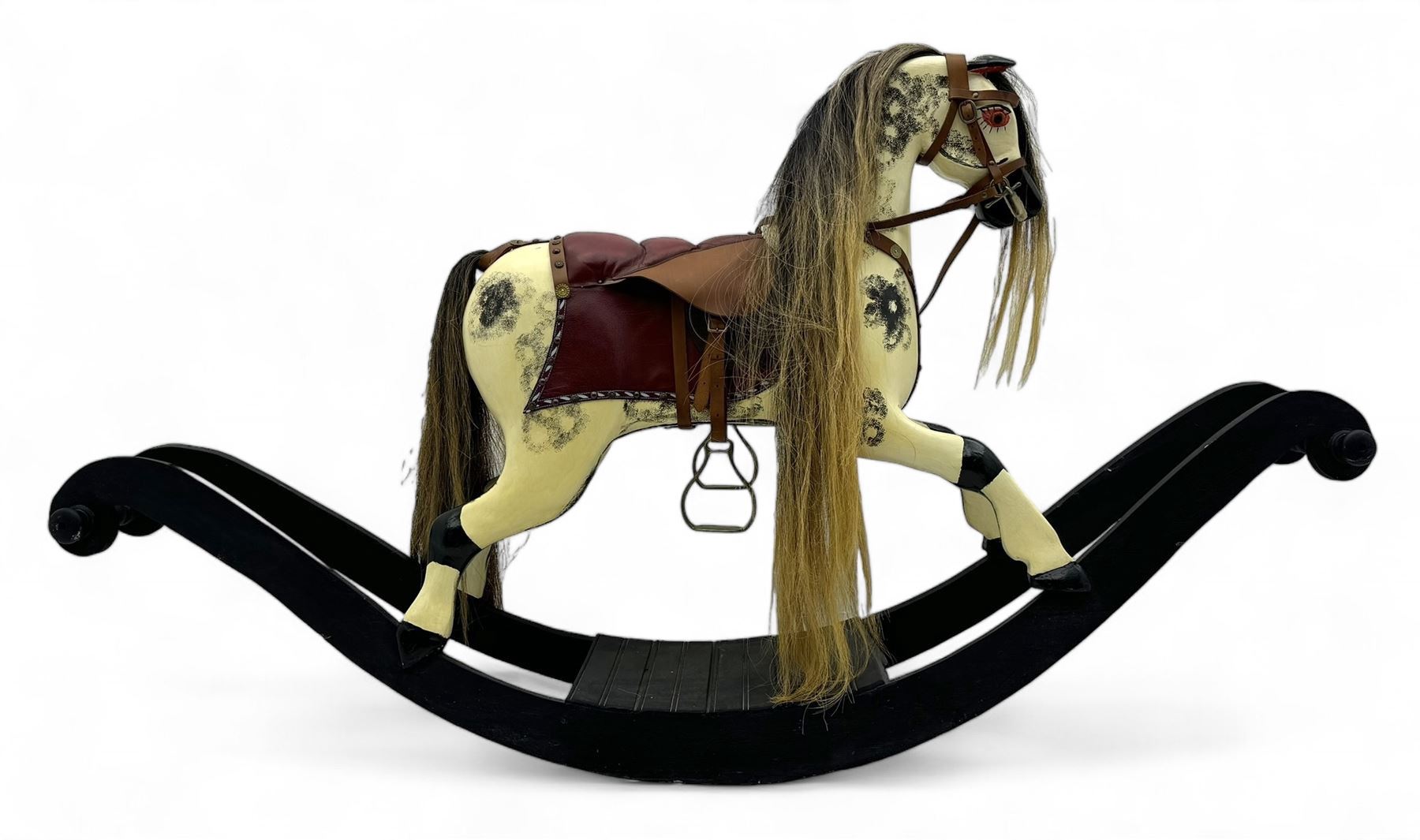 Mid-to-late 20th century carved wooden rocking horse, in dapple grey finish with leather saddle and bridle, mounted on a black painted rocking frame with shaped ends