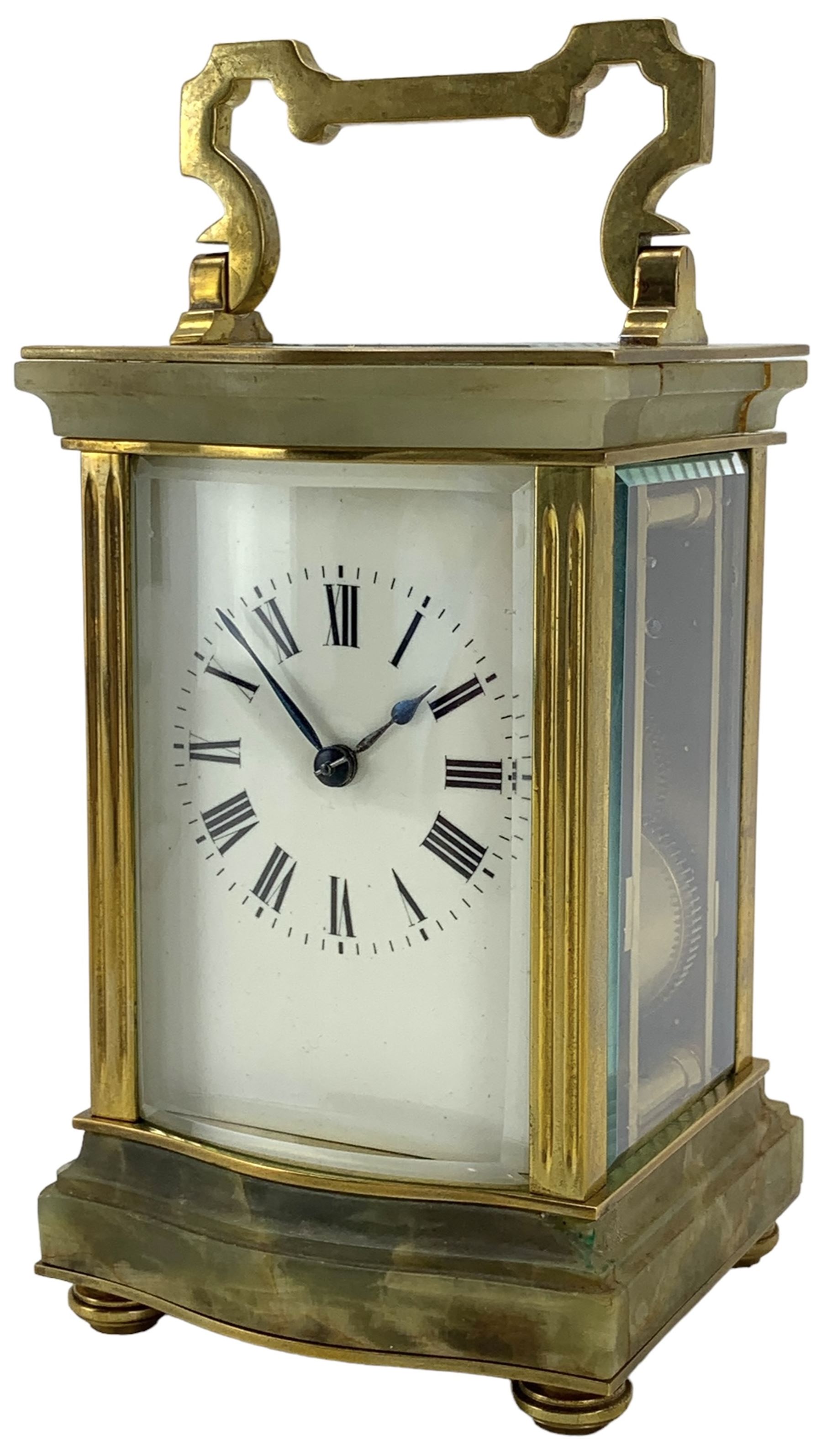 French - early 20th century two train carriage clock, in an onyx serpentine case raised on bun feet, with four bevelled panels and rectangular escapement viewing panel, white enamel dial with Roman numerals and steel spade hands, 8-day movement with a jewelled lever platform escapement and rack striking, sounding the hours and half hours on a coiled gong. With key.