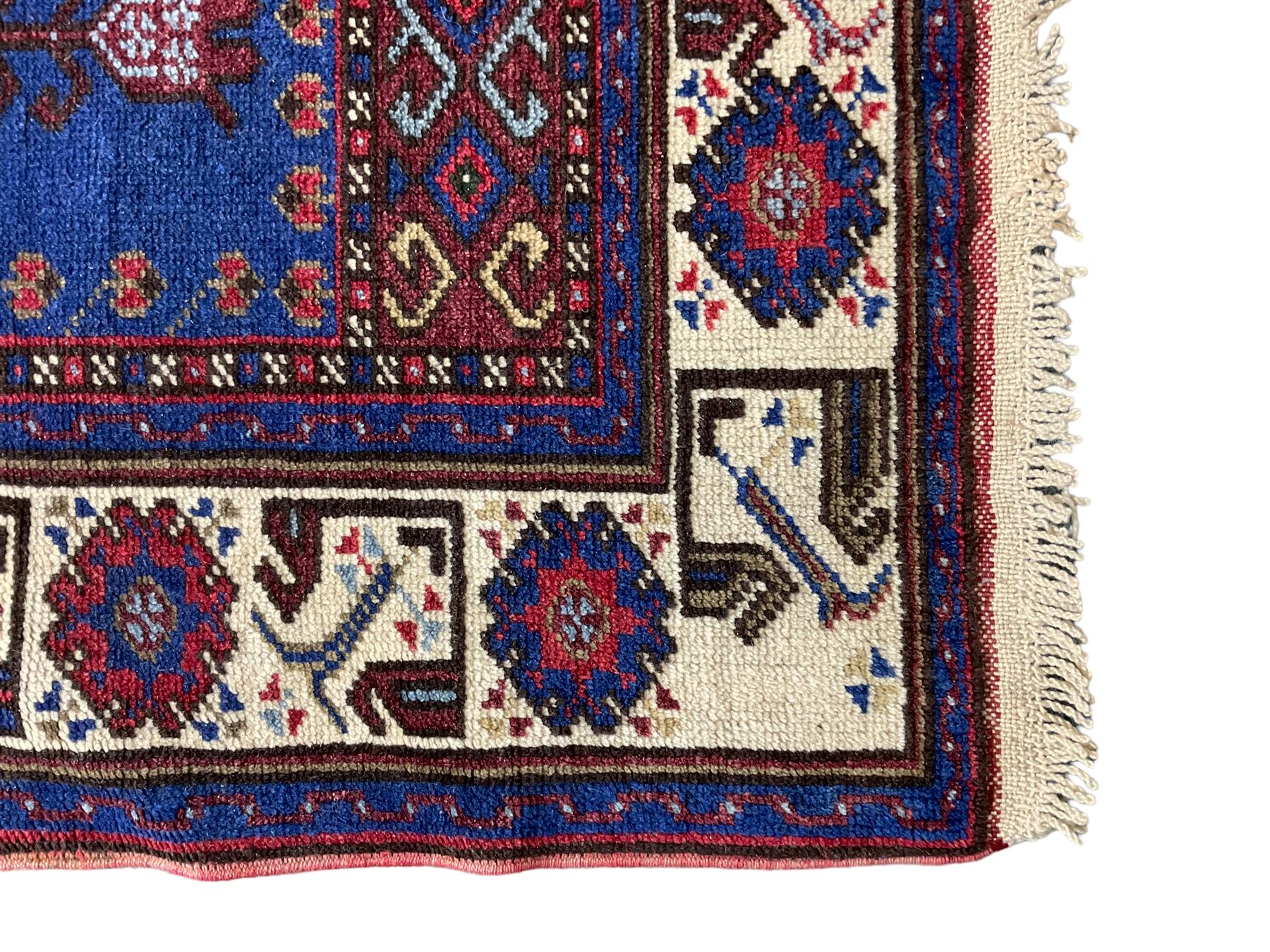 Turkish Yuruk indigo ground rug, the field decorated with geometric architectural designs, the guarded ivory border with repeating stylised plant motifs