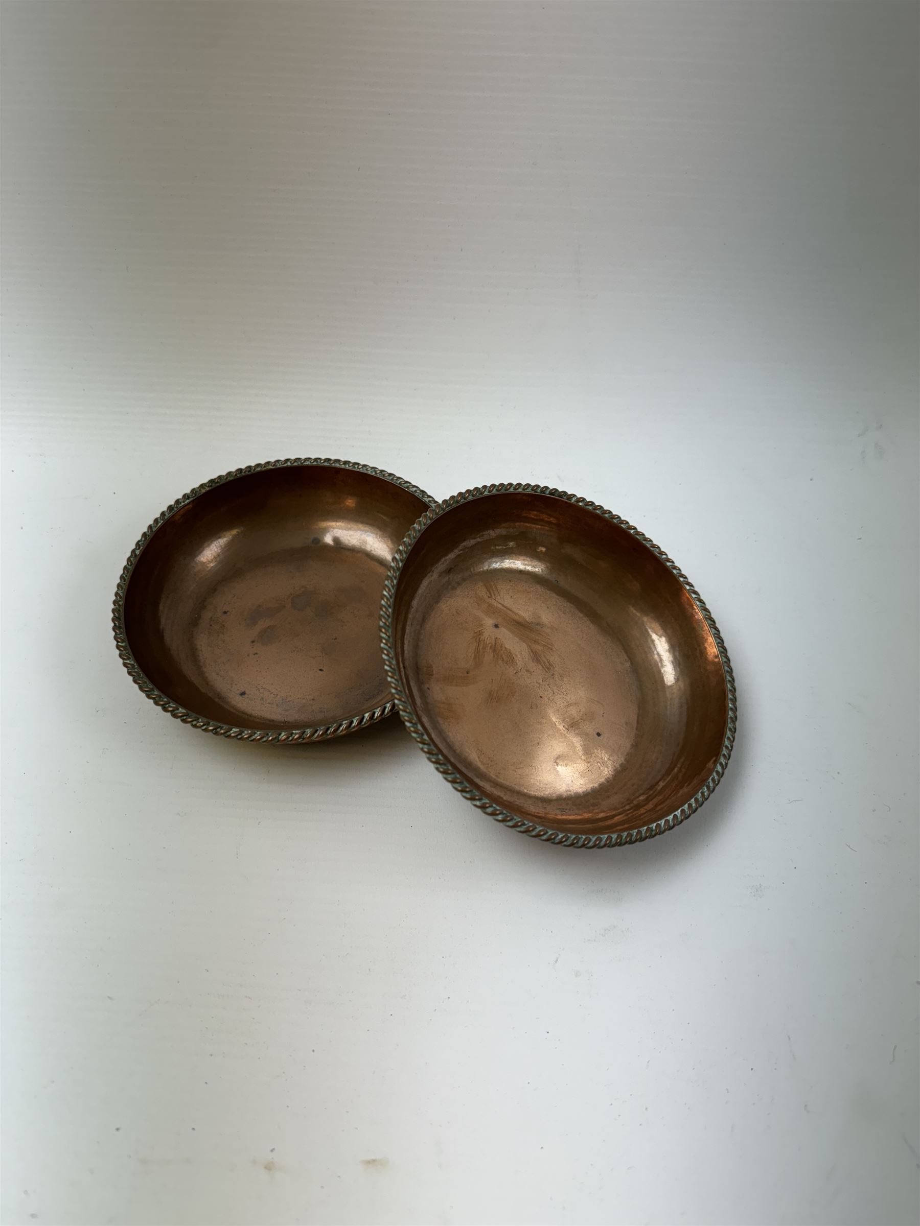 Pair of Arts & Crafts copper dishes by Gordon Russell, with lightly hammered finish and oblique gadrooned rim, impressed beneath 'Golf Hotel Grange Over Sands' and with maker's mark for Lygon