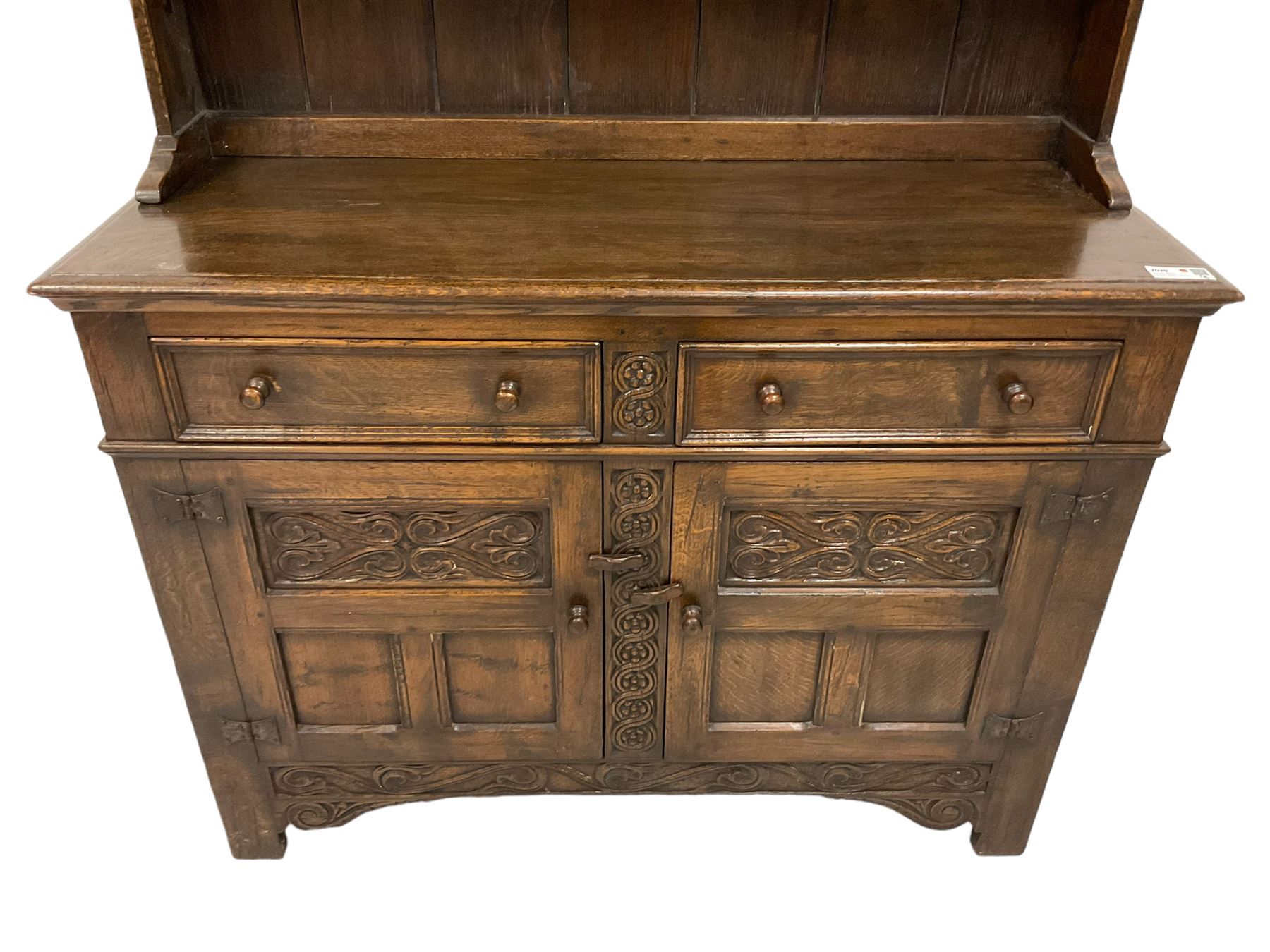 Georgian design oak dresser, two-tier plate rack with shaped aprons, the base fitted with two fielded moulded drawers, over two panelled cupboards carved with scrolling acanthus leaves, with guilloche carved central upright, on stile feet