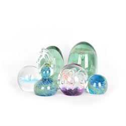 Two glass dump paperweights, with flower inclusions, together with four further glass paperweights