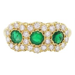 18ct gold emerald and diamond cluster ring, three round cut emeralds, with round brilliant cut diamond surround, London 1976