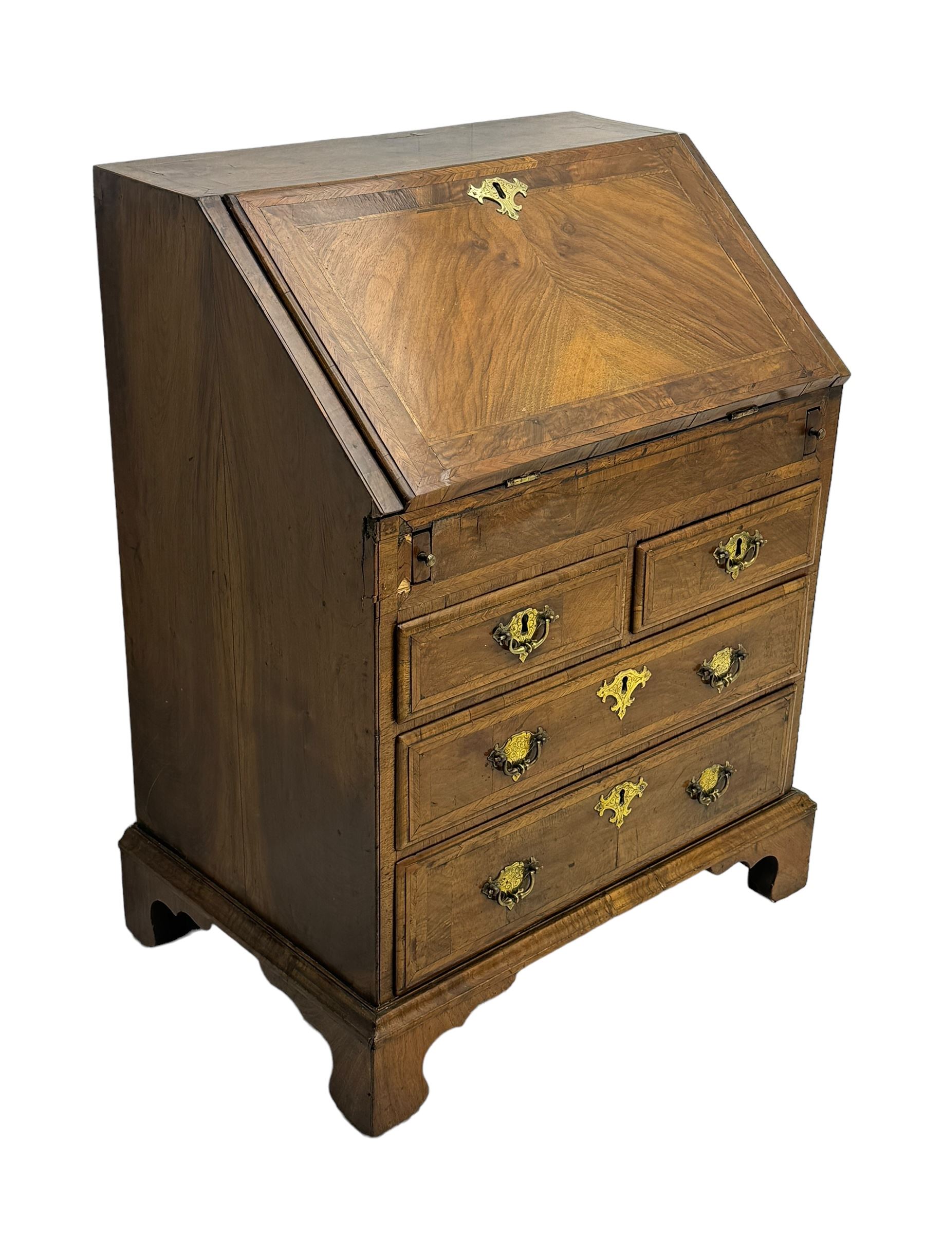 18th century walnut bureau, fall-front enclosing fitted interior with drawers and pigeonholes, over two short and two long drawers with brass escutcheon plates and handles, raised on bracket feet