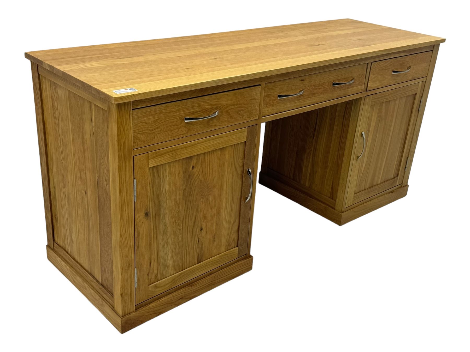 Contemporary light oak twin pedestal desk, fitted with three drawers over two cupboards with chrome handles, the central drawer with hinged front panel revealing pull-out keyboard tray, on plinth base