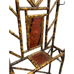 Victorian bamboo hallstand, bevelled mirror over red lacquered and chinoiserie decorated panels, fitted with six brass hooks 