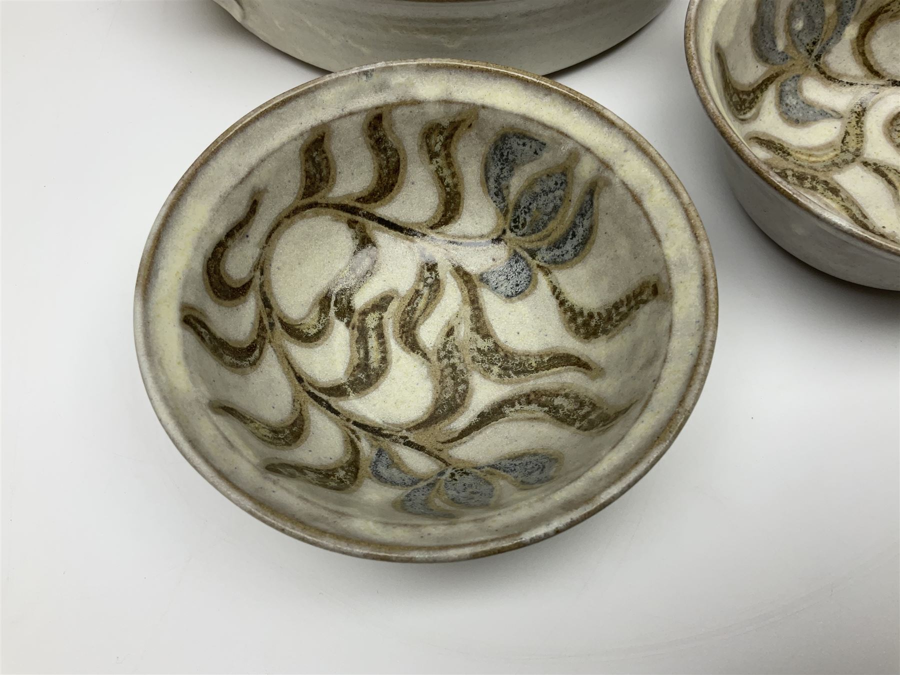 John Egerton (c1945-): studio pottery stoneware, comprising twin shallow covered dish, serving bowl and eight dessert bowls, all decorated with flowering sprigs on a cream ground, dish D28cm