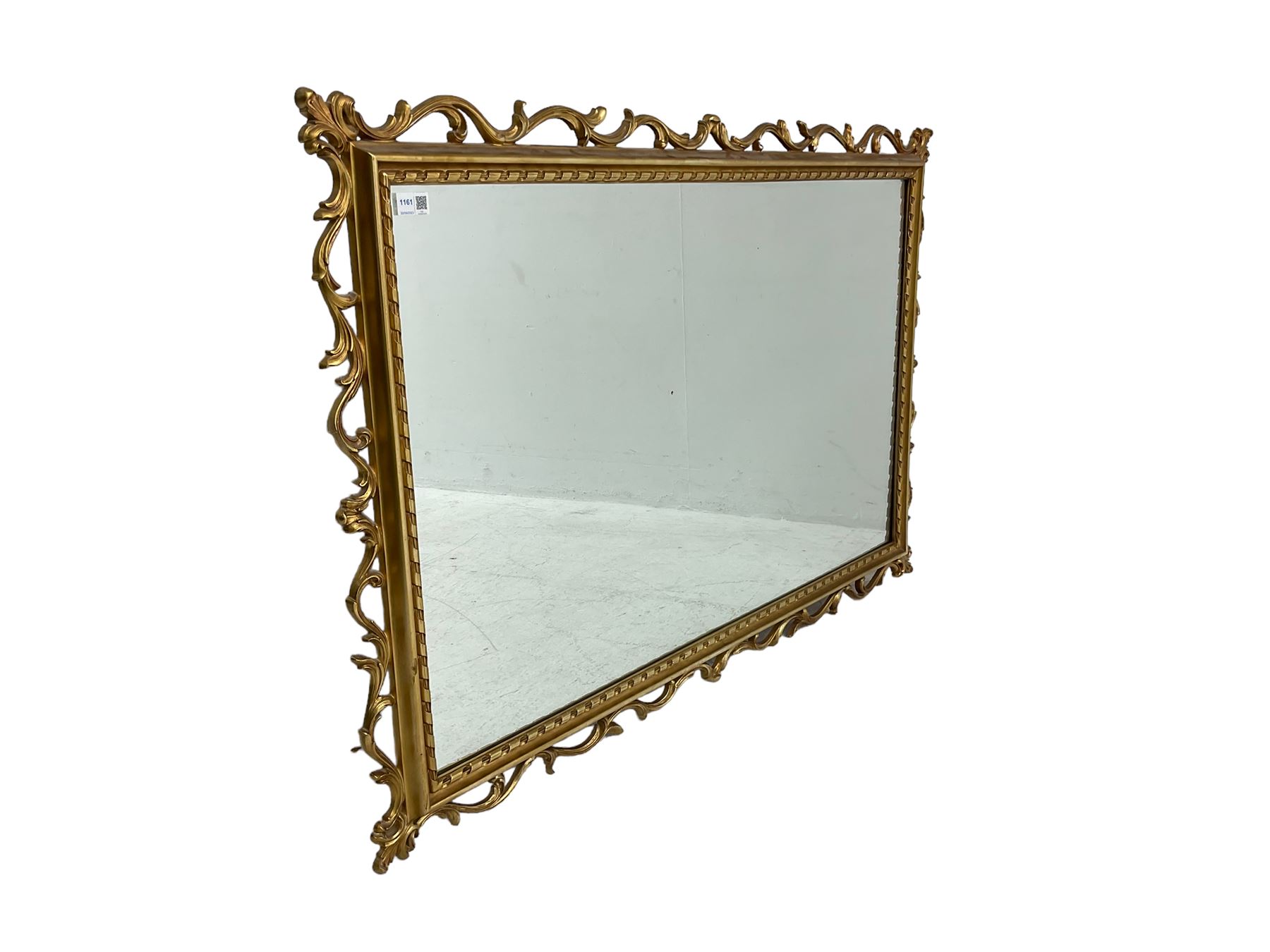 Ornate gilt framed mirror, decorated with trailing and scrolled foliage, plain mirror plate