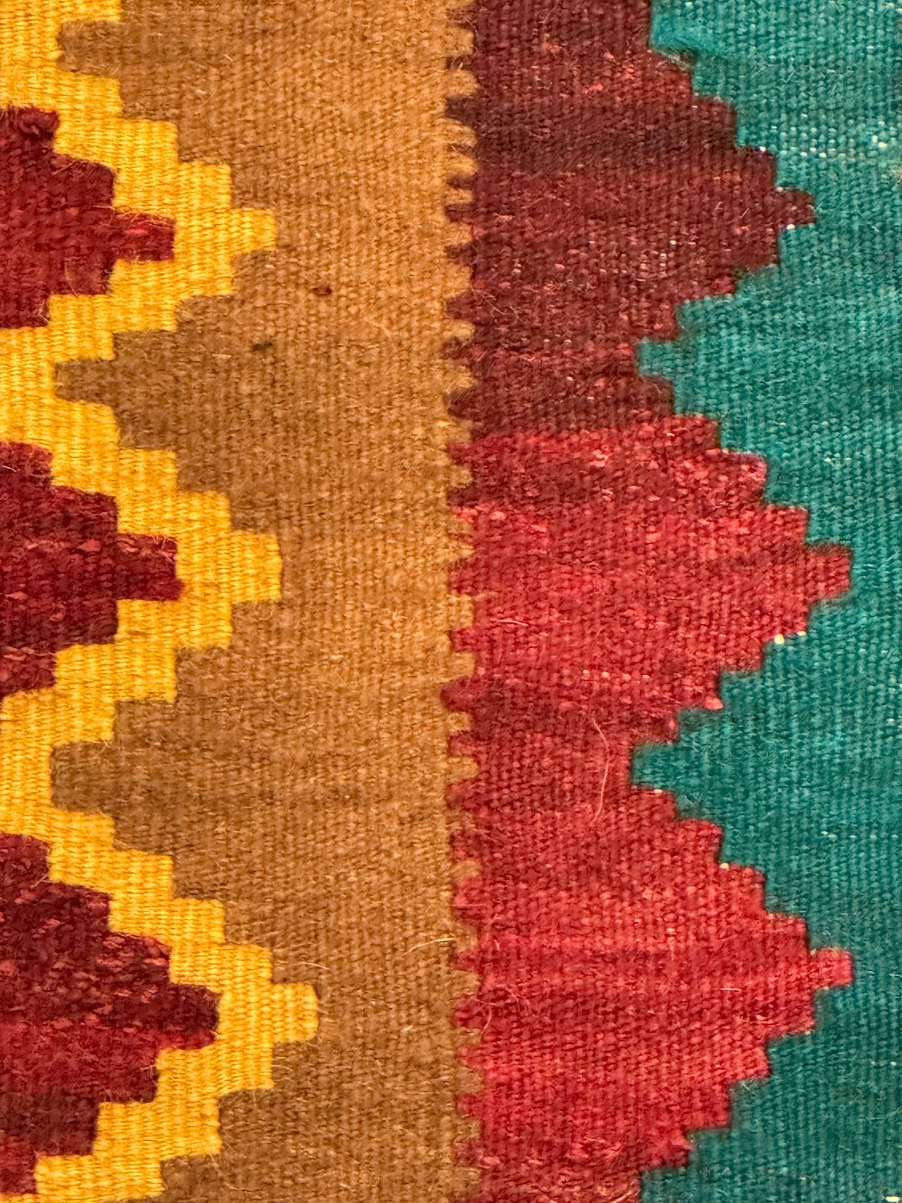 South West Persian Qashqai Kilim, crimson ground and decorated with three rows of geometric motifs, within zig-zag borders 