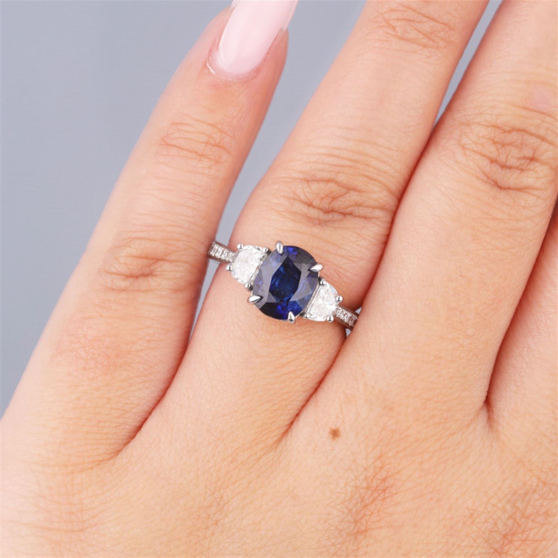 Platinum three stone oval cut sapphire and half moon cut diamond ring, with diamond set shoulders, hallmarked, sapphire 2.73 carat, total diamond weight approx 1.10 carat