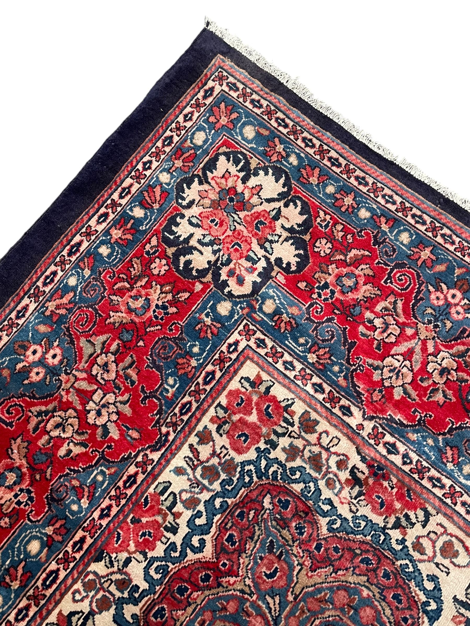 Persian Mahal indigo ground carpet, floral medallion on a field of swirling leafy branches and flower heads, shaped ivory field band decorated with flower head bouquets and trailing branches, the border decorated with floral motifs, within guard stripes