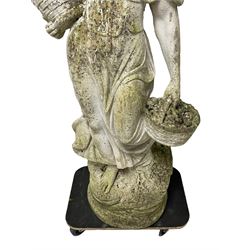 Weathered and painted cast stone garden statue, in the form of an Italian maiden carrying baskets with gathered flora and berries, on a shaped ovoid base