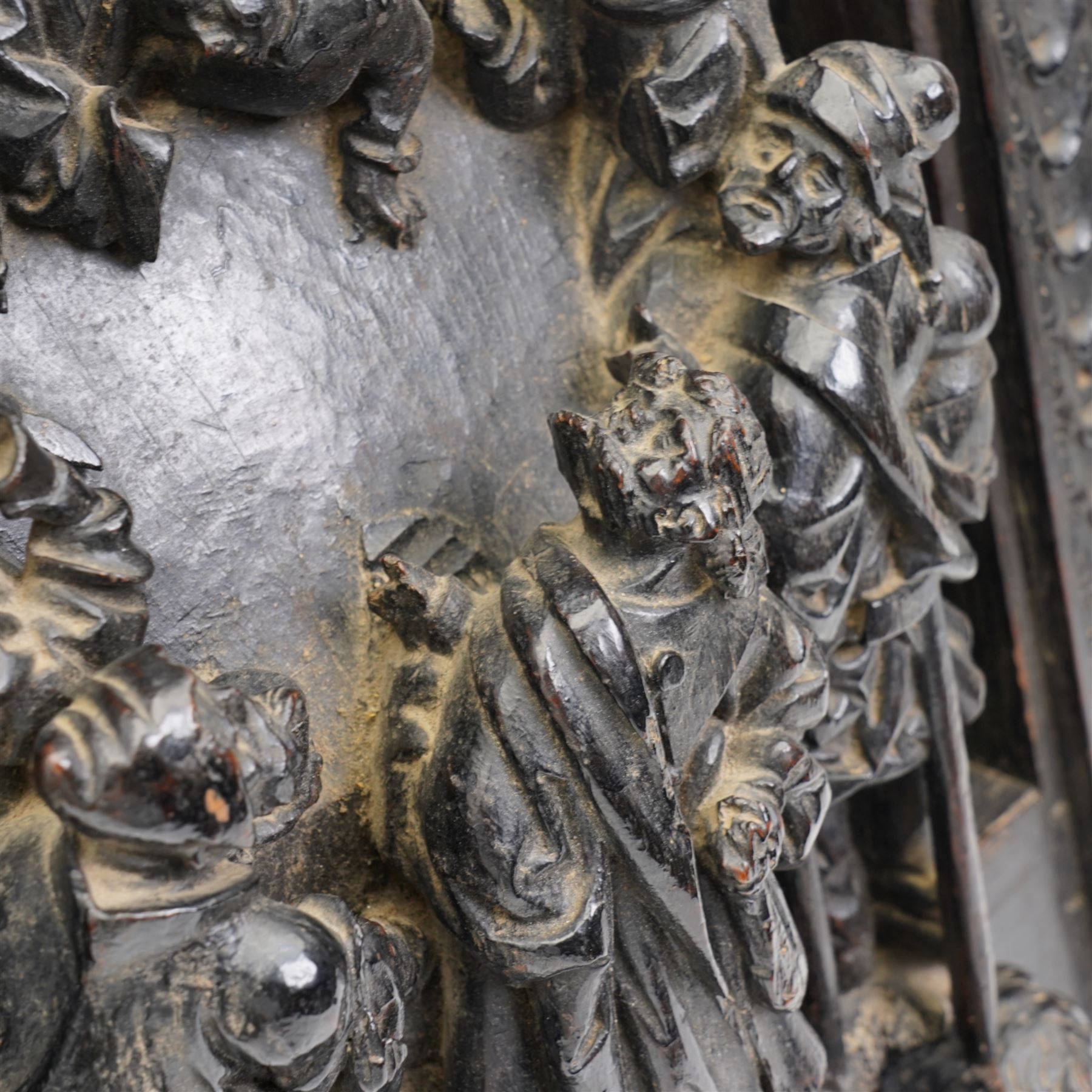 Late 17th century South German or Flemish carved oak figural group depicting 'The Last Supper', comprised of twelve figures facing each other around a central table, standing on on a later oak panel, the frieze carved with a central female mask flanked by foliate carvings, the group presented under an egg-and-dart carved arch, the base decorated with a protruding cartouche, flanked by cherub masks