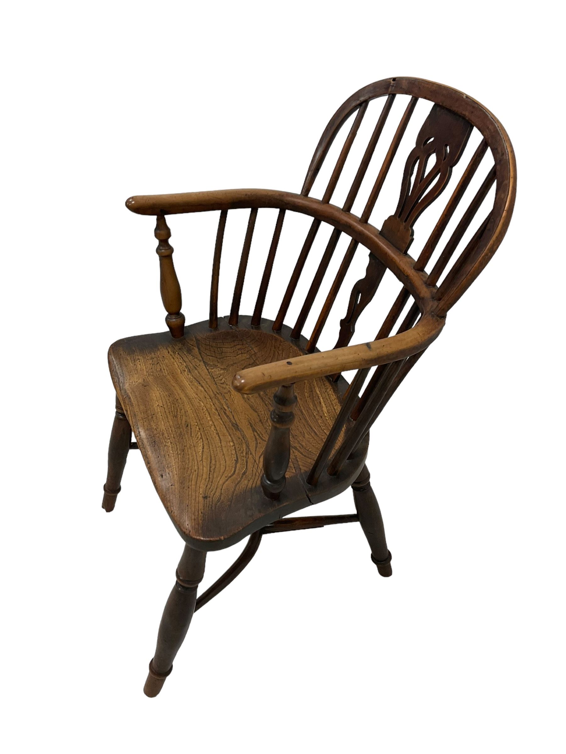 19th century yew wood and elm Windsor chair, low hoop stick back with pierced splat, dished seat raised on ring turned supports joined by crinoline stretcher