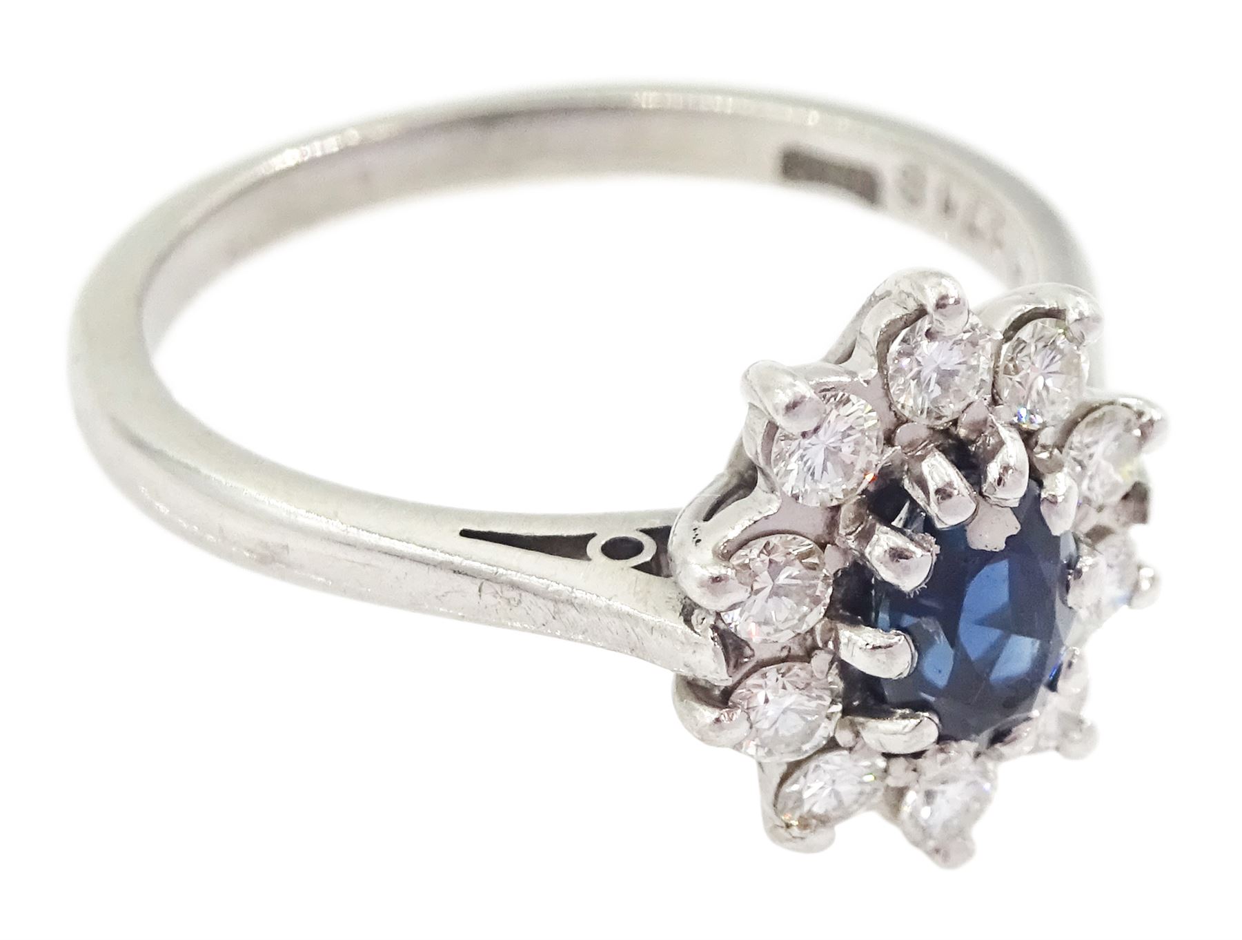 18ct white gold oval cut sapphire and round brilliant cut diamond cluster ring, London 1973, sapphire approx 0.50 carat, total diamond weight approx 0.30 carat 