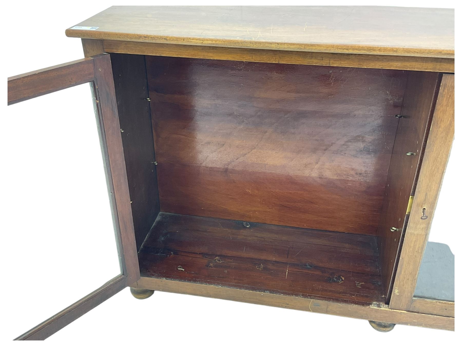 Early 20th century mahogany bookcase, rectangular top over two glazed doors, fitted with four adjustable shelves, on turned bun feet 