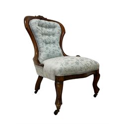 Victorian walnut nursing chair, the curved cresting rail carved with central cartouche and scroll leaves, upholstered in pale blue fabric decorated with trailing floral design, on cabriole front feet 