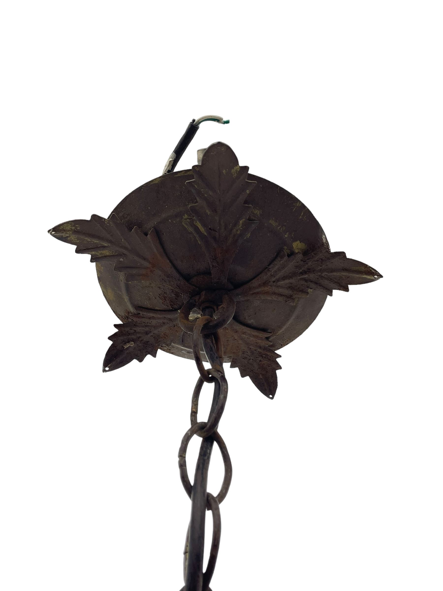 Early 20th century wrought metal chandelier, of scrolled form with six branches, decorated with leafage and glass pendants 